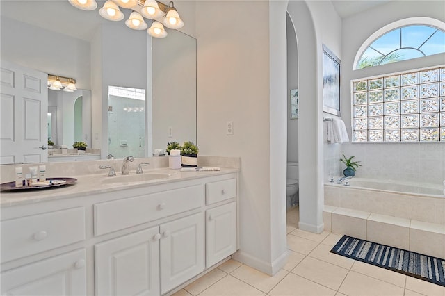 full bathroom featuring sink, tile patterned flooring, a notable chandelier, shower with separate bathtub, and toilet