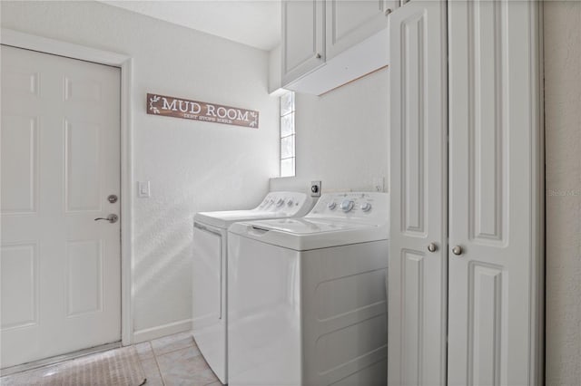 clothes washing area with cabinets, light tile patterned floors, and independent washer and dryer