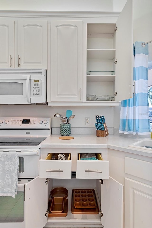 kitchen featuring white cabinetry and white appliances