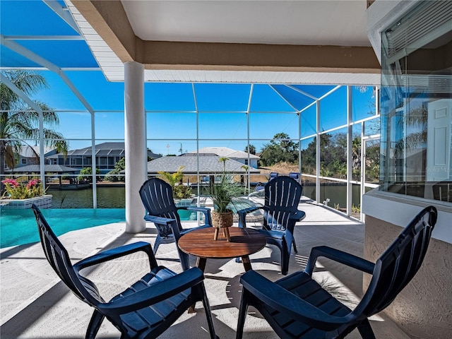 view of patio featuring a water view and a lanai