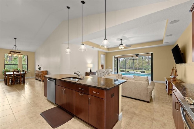 kitchen with hanging light fixtures, a raised ceiling, dark brown cabinets, and sink