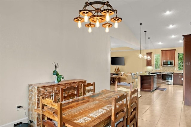 tiled dining space with an inviting chandelier, sink, and vaulted ceiling