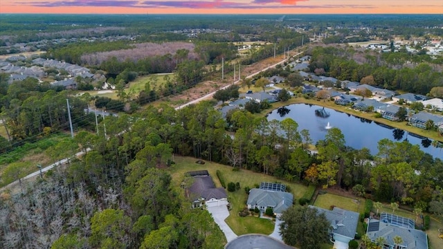 aerial view at dusk featuring a water view