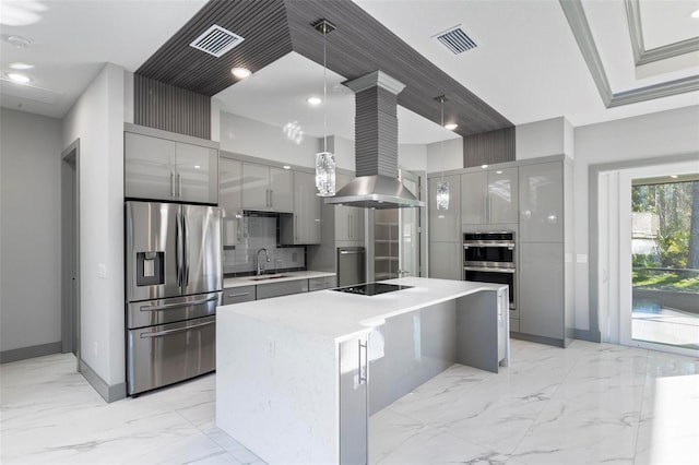 kitchen featuring appliances with stainless steel finishes, island range hood, sink, hanging light fixtures, and a center island