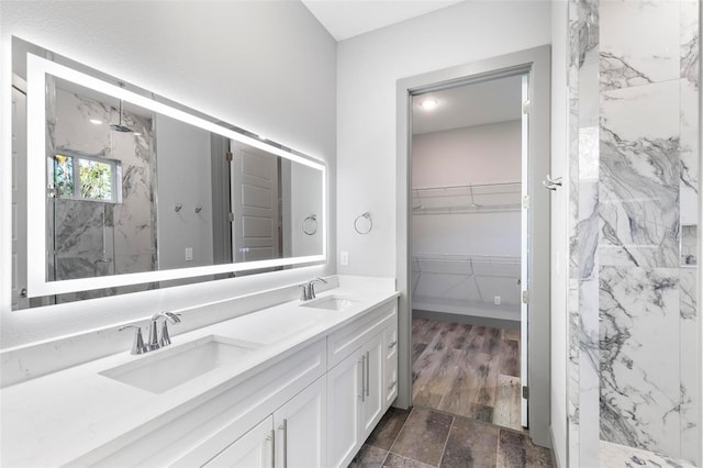 bathroom with vanity and a tile shower