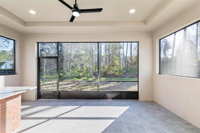 unfurnished sunroom featuring ceiling fan