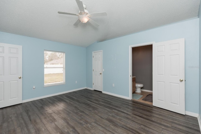 unfurnished bedroom with dark wood-type flooring, lofted ceiling, ensuite bathroom, a textured ceiling, and ceiling fan