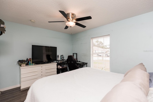 bedroom featuring ceiling fan, dark hardwood / wood-style flooring, and a textured ceiling