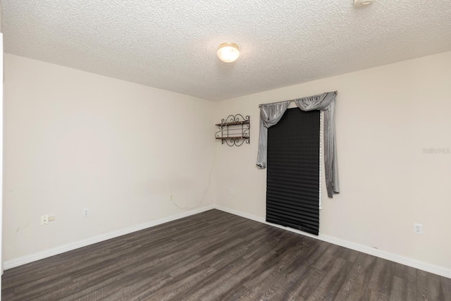 empty room featuring dark hardwood / wood-style flooring and a textured ceiling