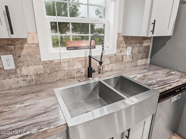 kitchen featuring backsplash, sink, light stone counters, and white cabinets