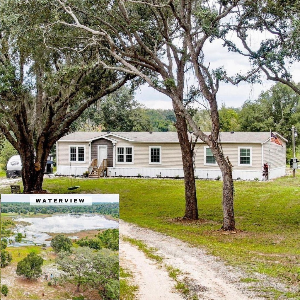 view of front of house with a front lawn and a water view