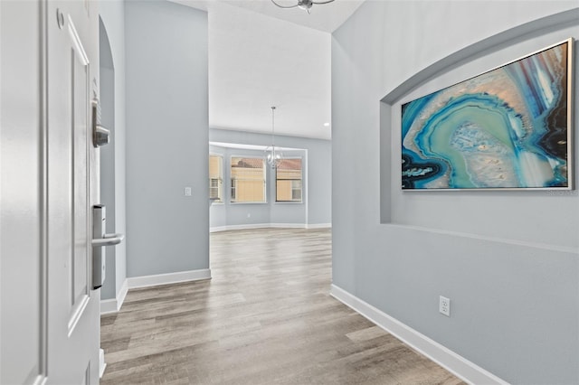 hallway featuring a chandelier and light hardwood / wood-style floors