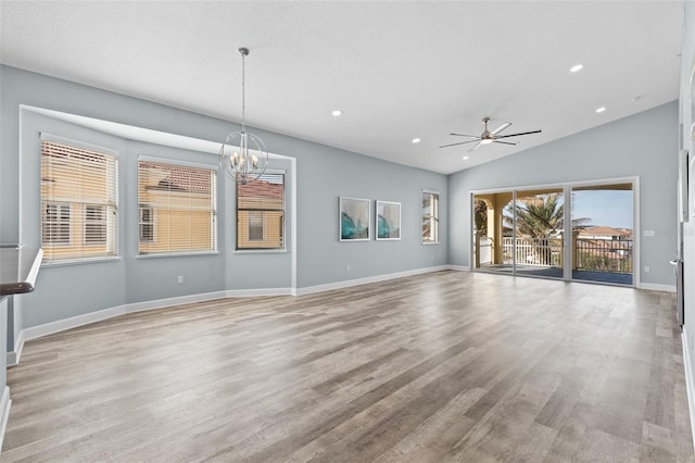 unfurnished living room featuring ceiling fan with notable chandelier, lofted ceiling, and light hardwood / wood-style floors