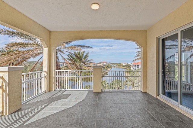 view of patio featuring a balcony and a water view