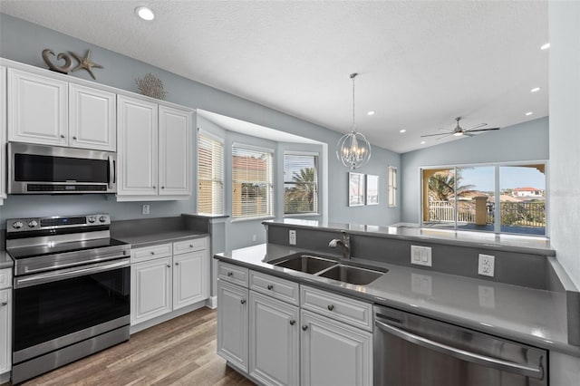 kitchen featuring white cabinetry, appliances with stainless steel finishes, sink, and pendant lighting