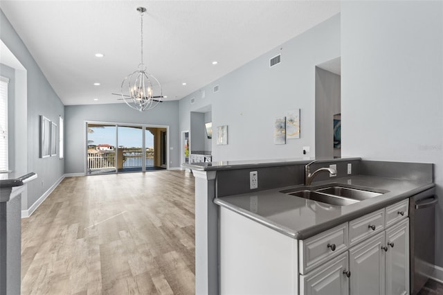 kitchen with sink, an inviting chandelier, light wood-type flooring, dishwasher, and white cabinets