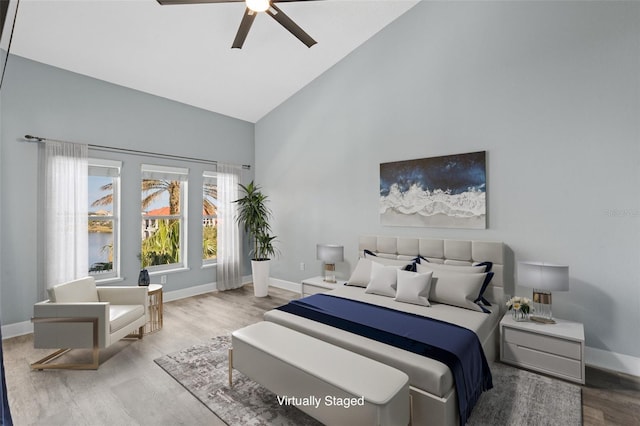 bedroom featuring light hardwood / wood-style flooring, high vaulted ceiling, and ceiling fan