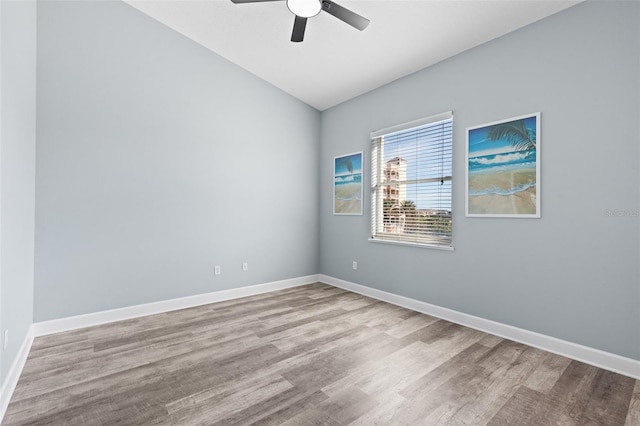 spare room featuring vaulted ceiling, light hardwood / wood-style floors, and ceiling fan