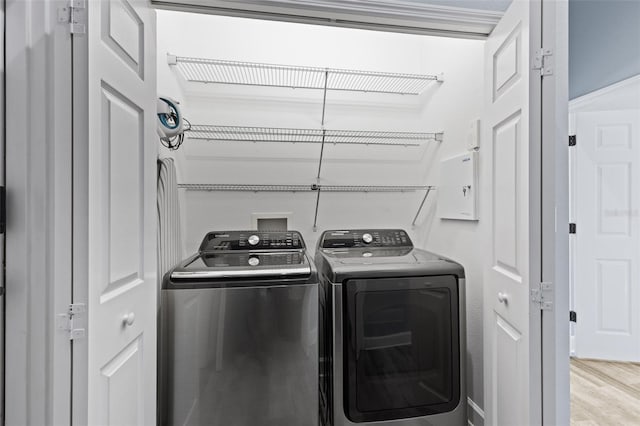 clothes washing area featuring light hardwood / wood-style flooring and washing machine and dryer