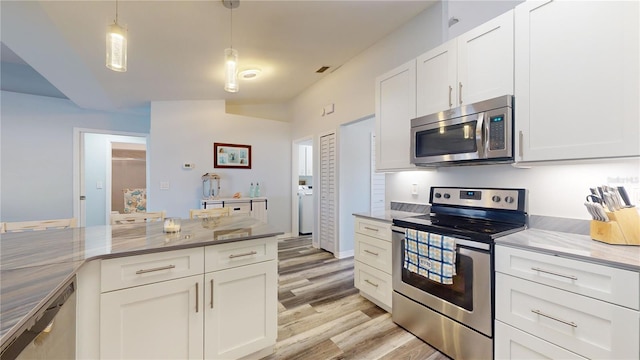 kitchen featuring decorative light fixtures, white cabinets, stainless steel appliances, light stone countertops, and light wood-type flooring