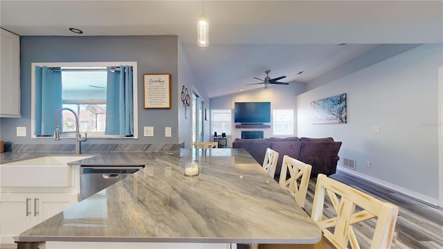 dining room with vaulted ceiling, ceiling fan, sink, and a wealth of natural light