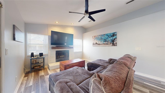 living room featuring ceiling fan, lofted ceiling, hardwood / wood-style floors, and a fireplace