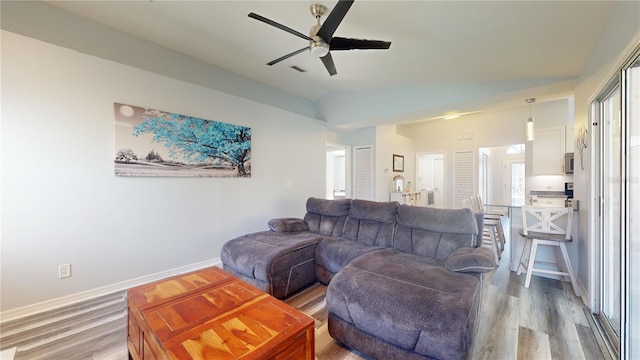 living room featuring hardwood / wood-style flooring, vaulted ceiling, and ceiling fan