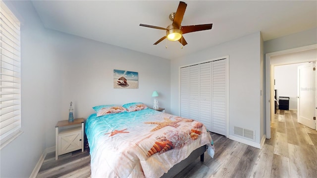 bedroom featuring wood-type flooring, ceiling fan, and a closet