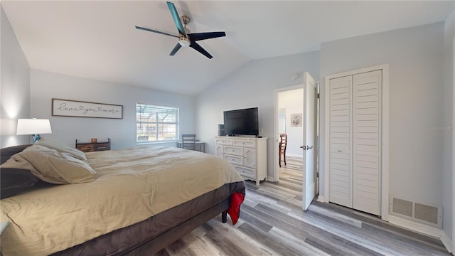 bedroom with ceiling fan, light hardwood / wood-style floors, and vaulted ceiling