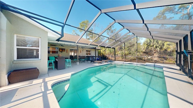 view of pool with a lanai, an outdoor bar, and a patio area