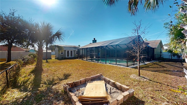 view of yard featuring a fenced in pool, an outdoor structure, and glass enclosure