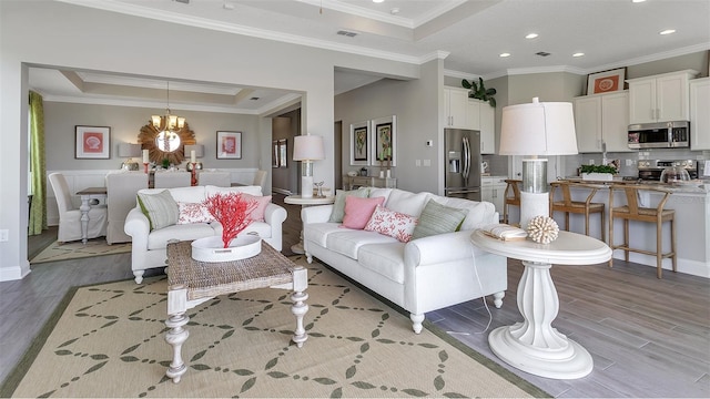 living room with crown molding, light hardwood / wood-style floors, and a raised ceiling