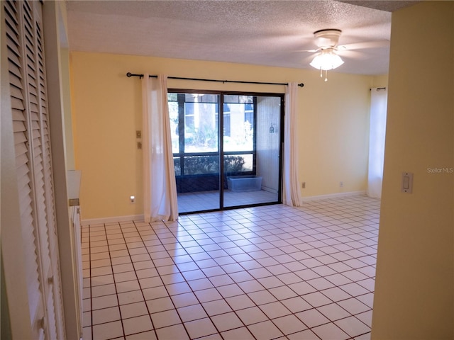 empty room featuring light tile patterned floors, a textured ceiling, and ceiling fan