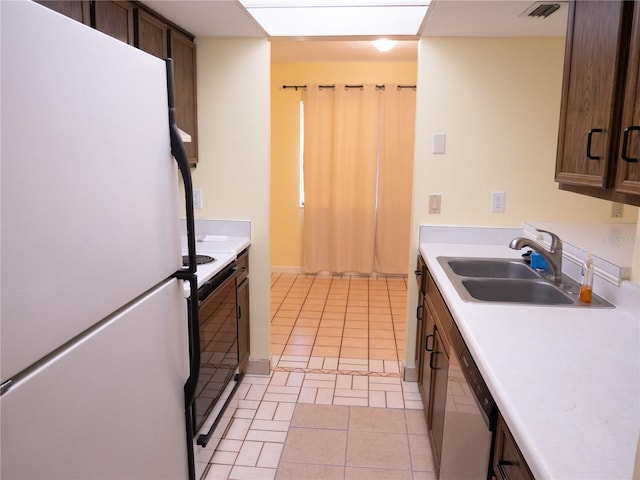 kitchen featuring electric range, light countertops, a sink, and freestanding refrigerator