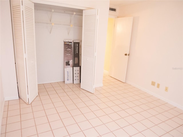 unfurnished bedroom featuring visible vents, a closet, and light tile patterned flooring