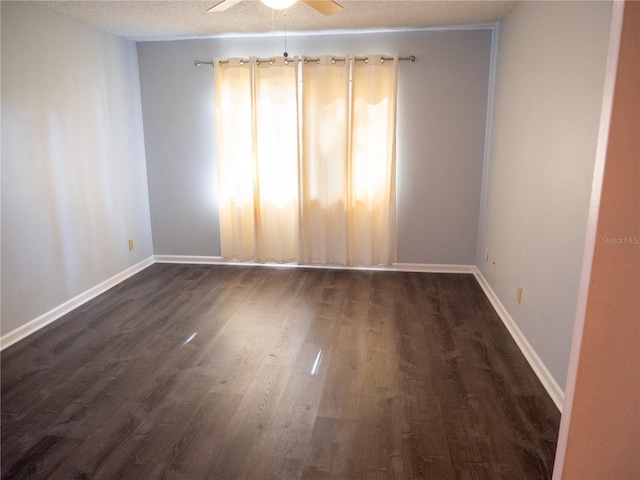 unfurnished room featuring baseboards, a textured ceiling, a ceiling fan, and dark wood-style flooring