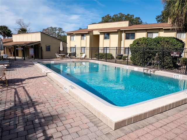 community pool featuring a patio area and fence