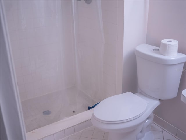 full bathroom with toilet, a stall shower, and tile patterned flooring