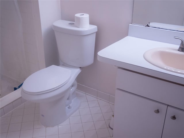 bathroom featuring a shower, toilet, vanity, tile patterned flooring, and baseboards