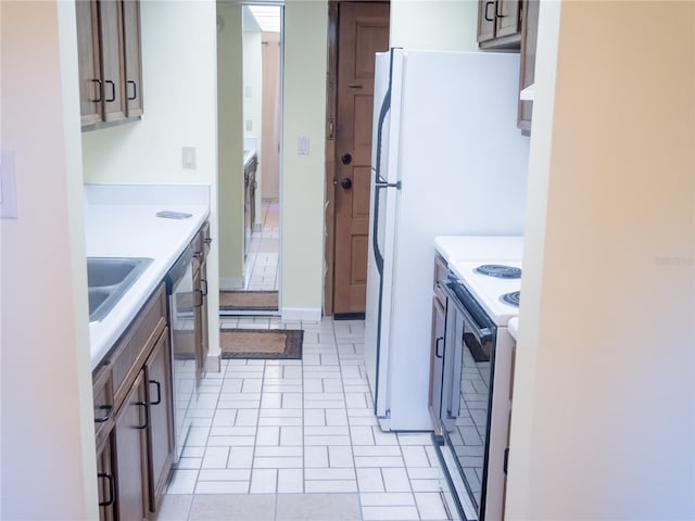 kitchen with baseboards, white range with electric cooktop, dishwasher, light countertops, and a sink