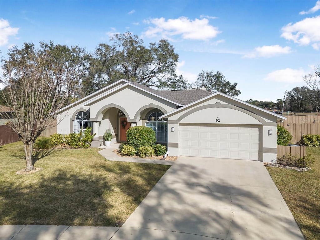 single story home with a garage and a front yard