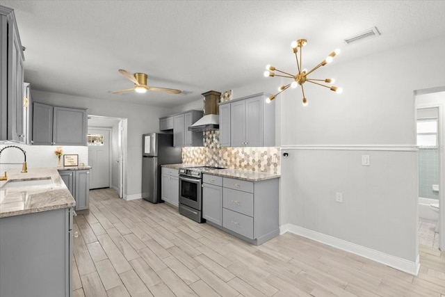 kitchen with stainless steel appliances, sink, light stone counters, and gray cabinets