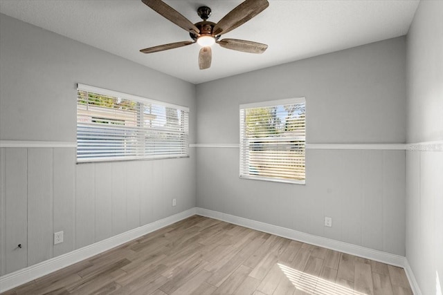 spare room featuring light hardwood / wood-style flooring, plenty of natural light, and ceiling fan