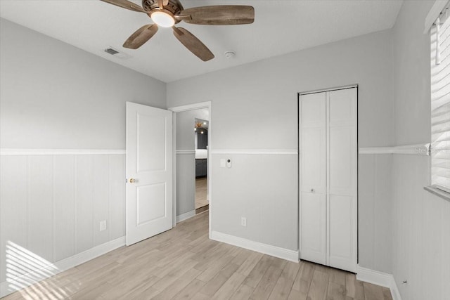 unfurnished bedroom with ceiling fan and light wood-type flooring