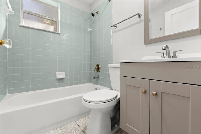 full bathroom with tile patterned flooring, tiled shower / bath, vanity, and toilet