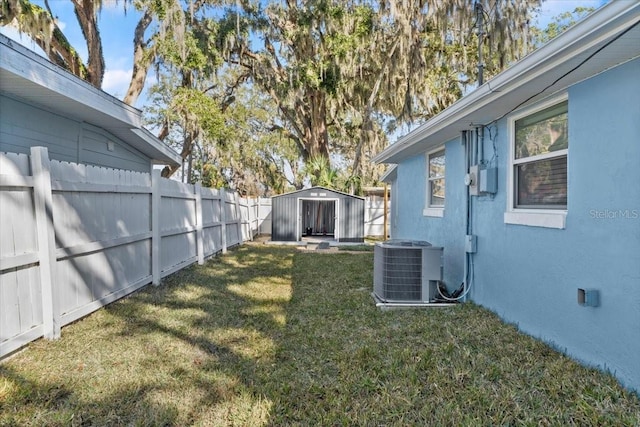 view of yard with central AC unit and a storage shed