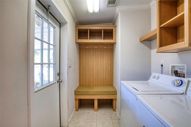 laundry area with crown molding, washer and clothes dryer, and light tile patterned flooring