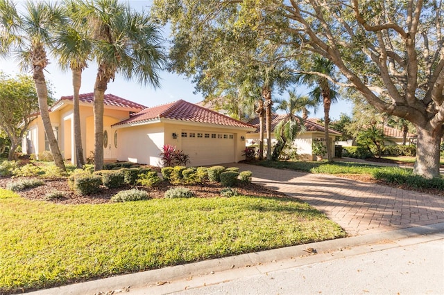 mediterranean / spanish house with a garage and a front yard