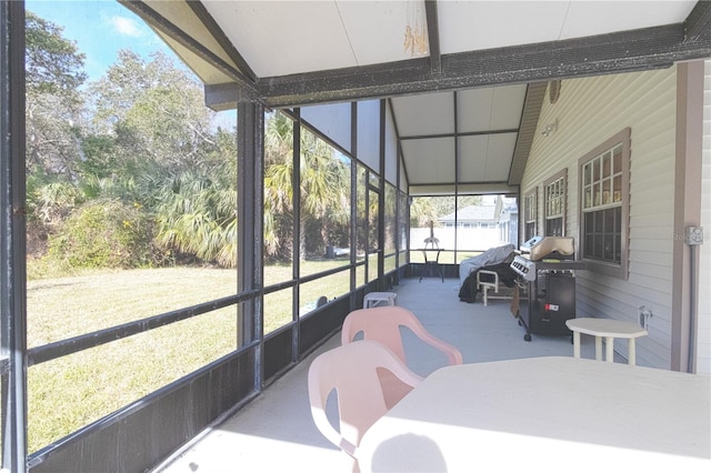 sunroom / solarium featuring beam ceiling