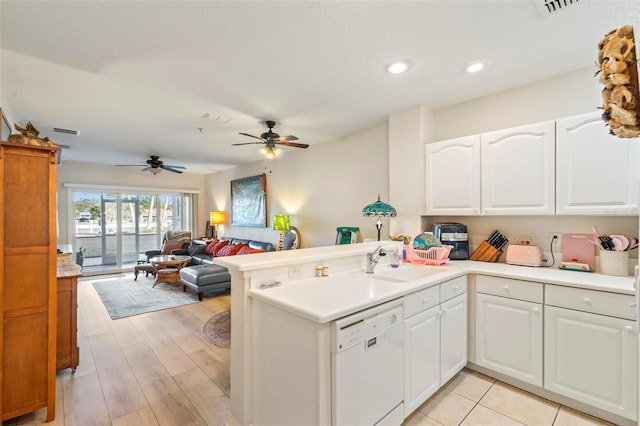 kitchen featuring dishwasher, sink, kitchen peninsula, and white cabinets